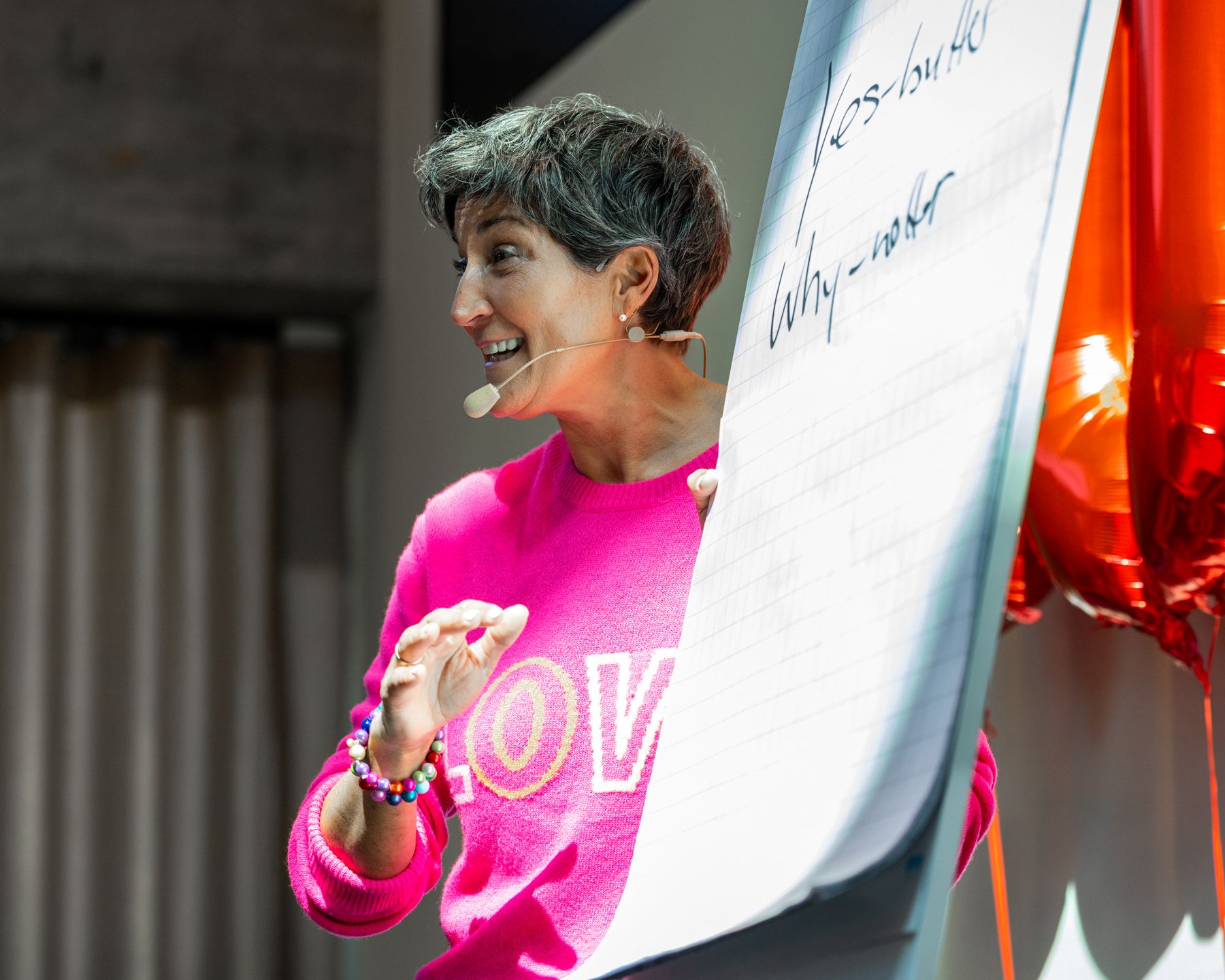 Speakerin am Flipchart mit Headset-Mikrofon